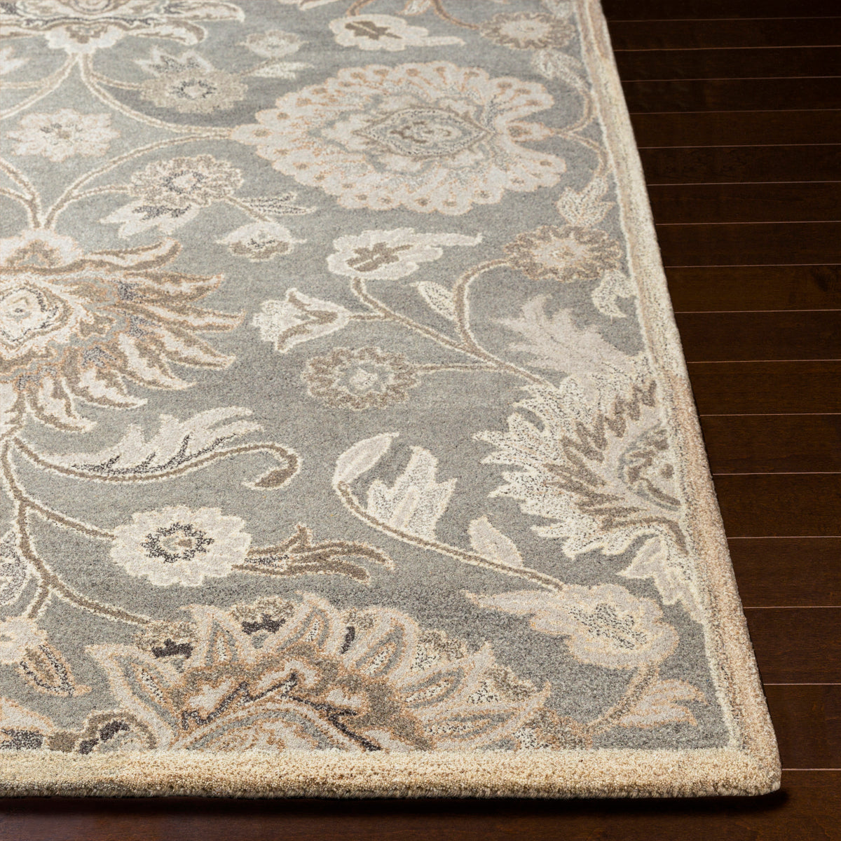 Mediterranean Seal hand-tufted wool rug with grey, taupe, and ivory floral patterns on dark wood floor.