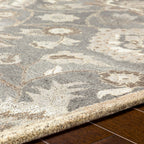 Close-up of the Mediterranean Seal hand-tufted wool rug, showing its grey and ivory floral pattern.