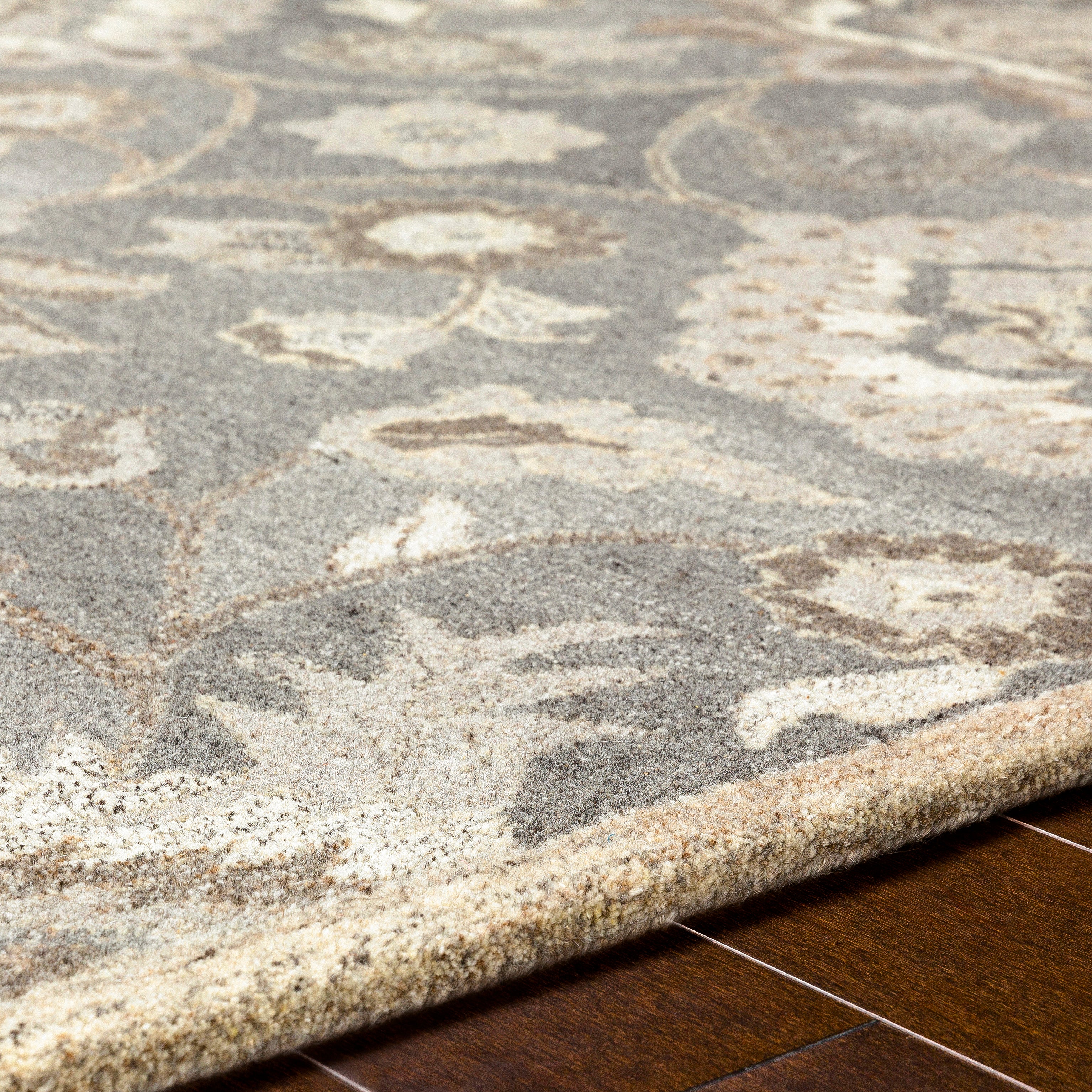 Close-up of the Mediterranean Seal hand-tufted wool rug, showing its grey and ivory floral pattern.
