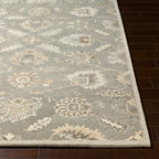 Rubicon Oyster hand-tufted wool rug with grey, beige, and ivory floral patterns on dark wood floor.