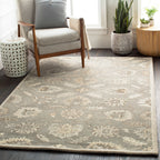 Rubicon Oyster hand-tufted wool rug with a beige and grey floral pattern in a living room.