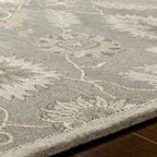 Rubicon Oyster hand-tufted wool rug with grey and ivory floral patterns on hardwood floor