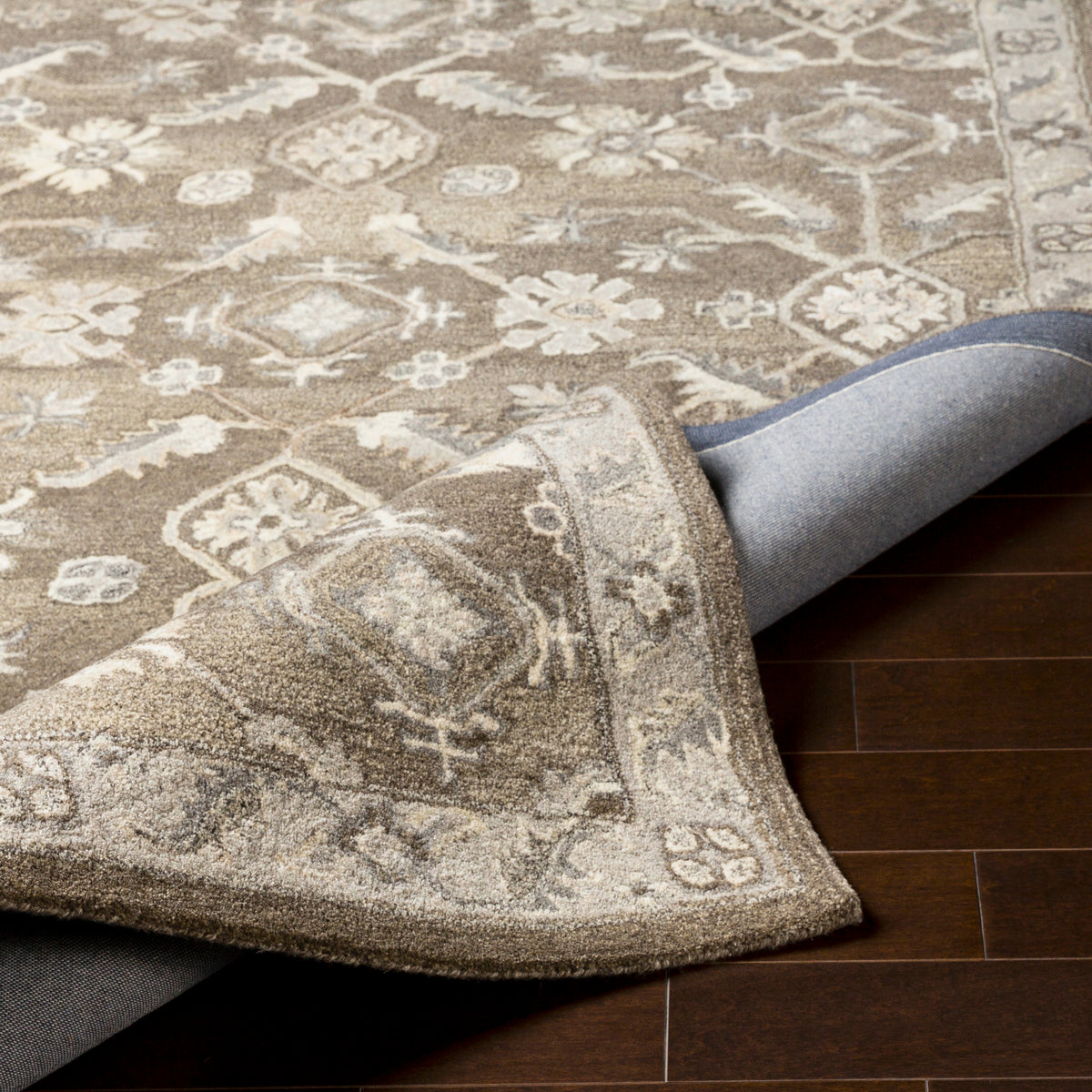 Euphrates Mocha Hand-Tufted wool rug with neutral brown floral patterns and a folded corner.