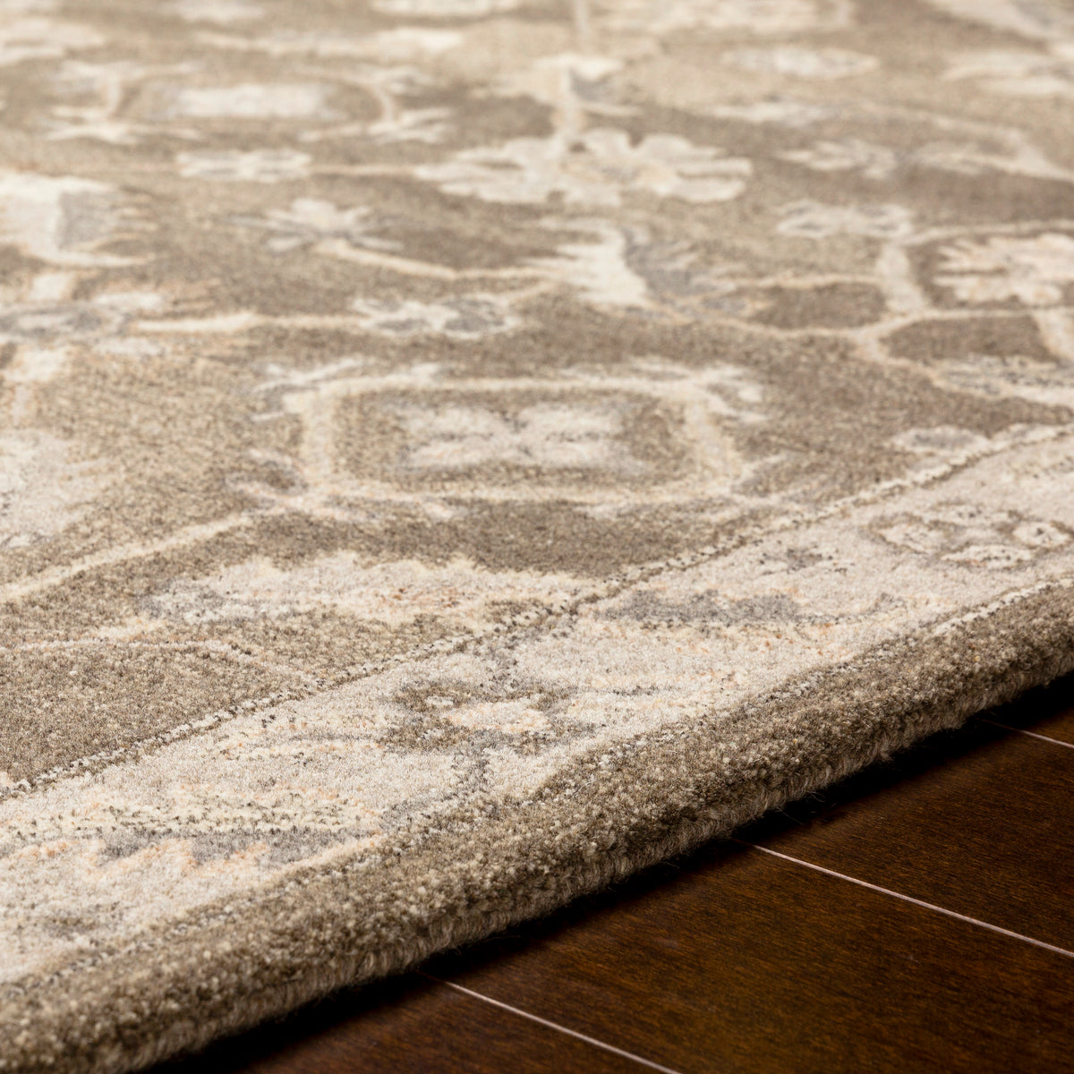 Euphrates Mocha hand-tufted wool rug with neutral brown floral patterns on dark wood floor.