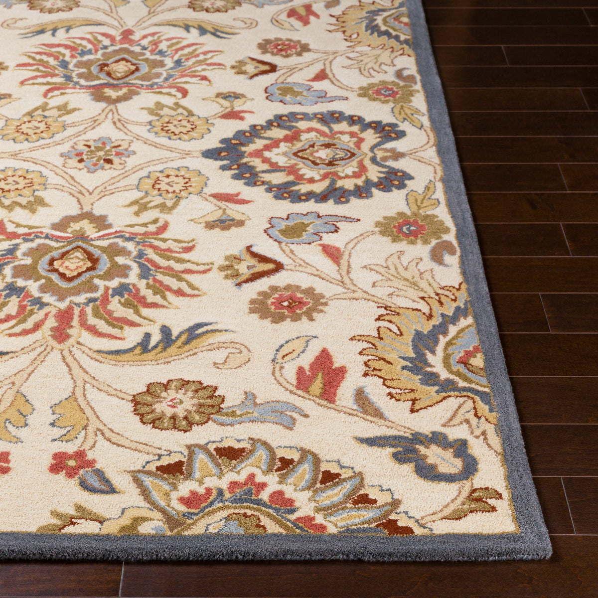 Mediterranean Fiesta hand-tufted wool rug with colorful floral patterns on a dark wood floor.