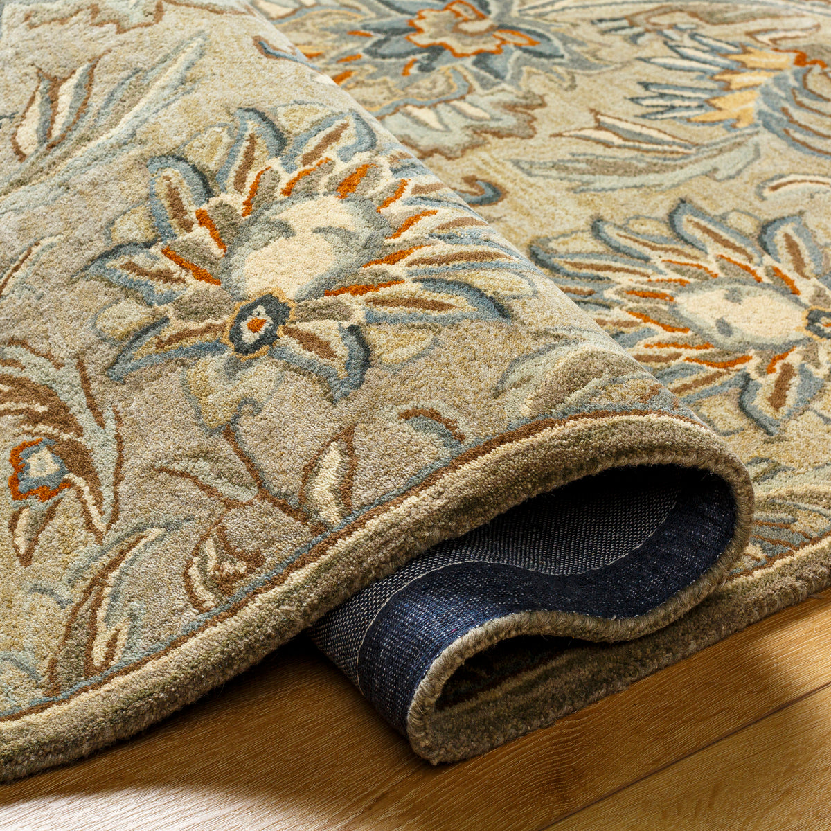 Mediterranean Pewter hand-tufted wool rug with gray, brick red, and slate floral patterns.