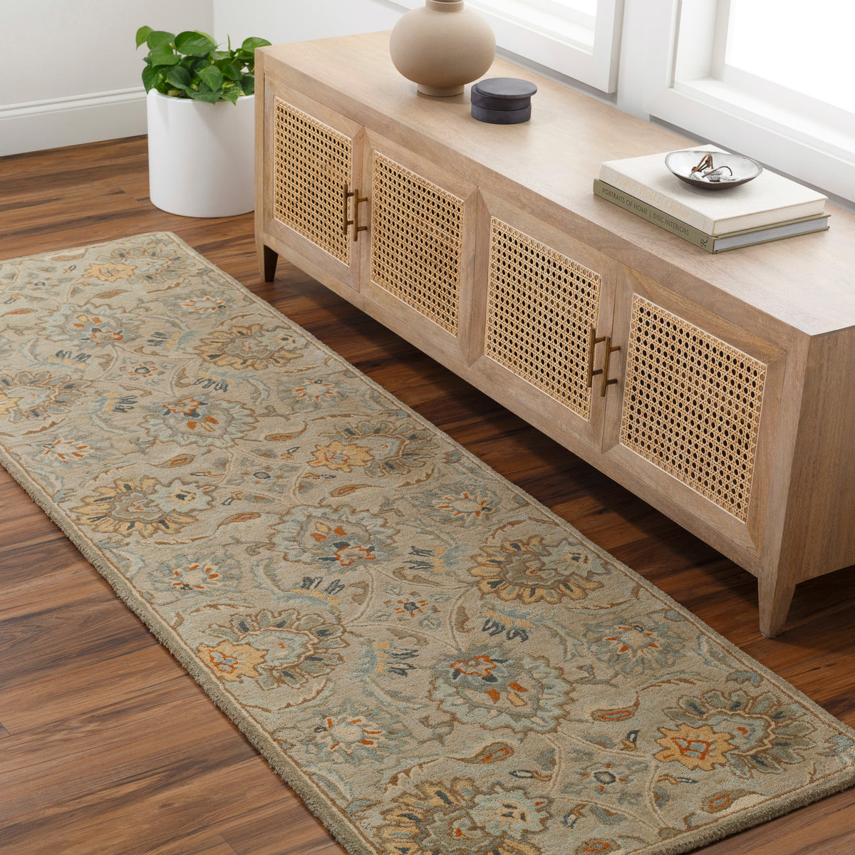 Mediterranean Pewter wool runner rug with floral patterns in gray, brick red, and tan on hardwood floor.