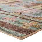 Hazan hand-knotted wool rug with a colorful geometric pattern in green, brown, and pink.
