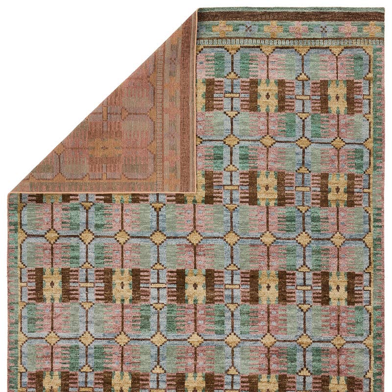 Hazan hand-knotted wool rug with a colorful geometric pattern in green, pink, blue, and brown.