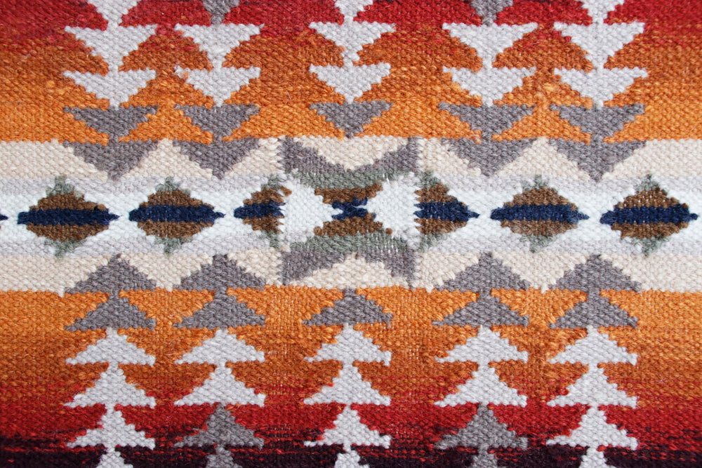 Pendleton Juniper Mesa wool rug with orange, red, and grey Southwest geometric patterns.