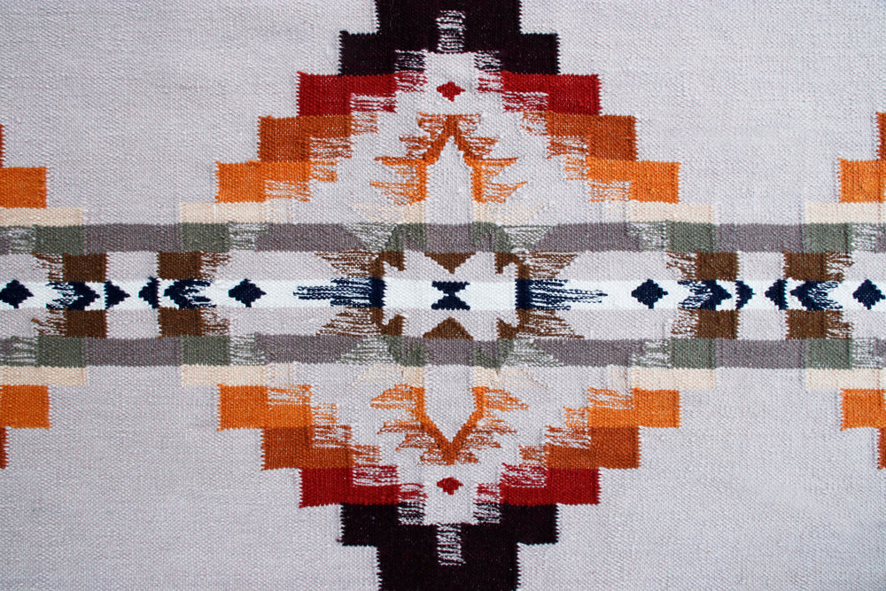 Pendleton Juniper Mesa flat-weave wool rug with orange and grey Southwest pattern.