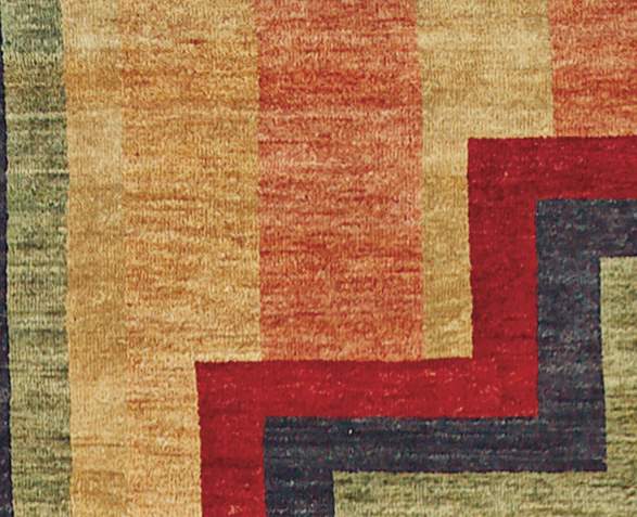 Detail of a hand-knotted wool rug with Southwest geometric patterns in red, gold, and green.