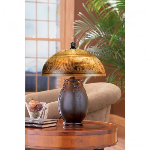 Glenhaven Table Lamp with etched amber art glass shade and sculpted bronze base on a wooden table