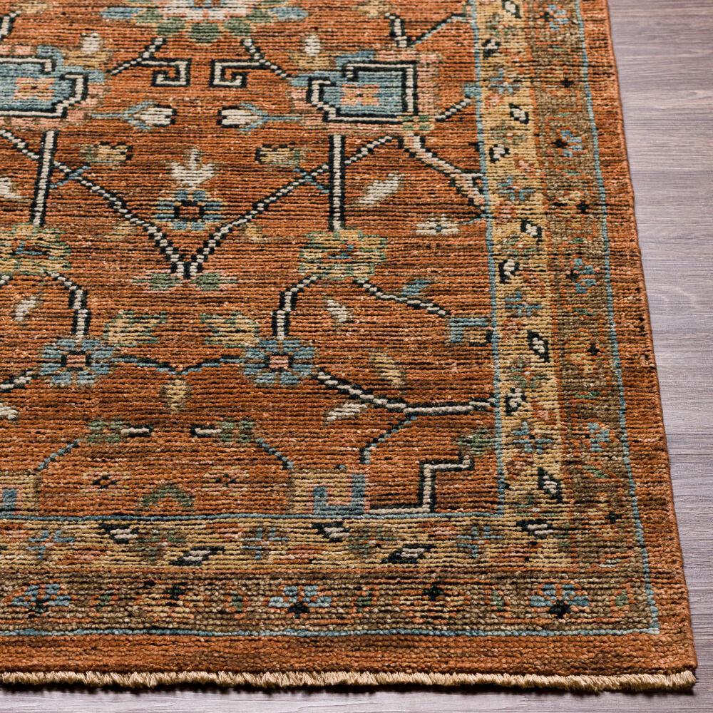 Reign hand-knotted wool rug in rust orange with blue and green traditional patterns.