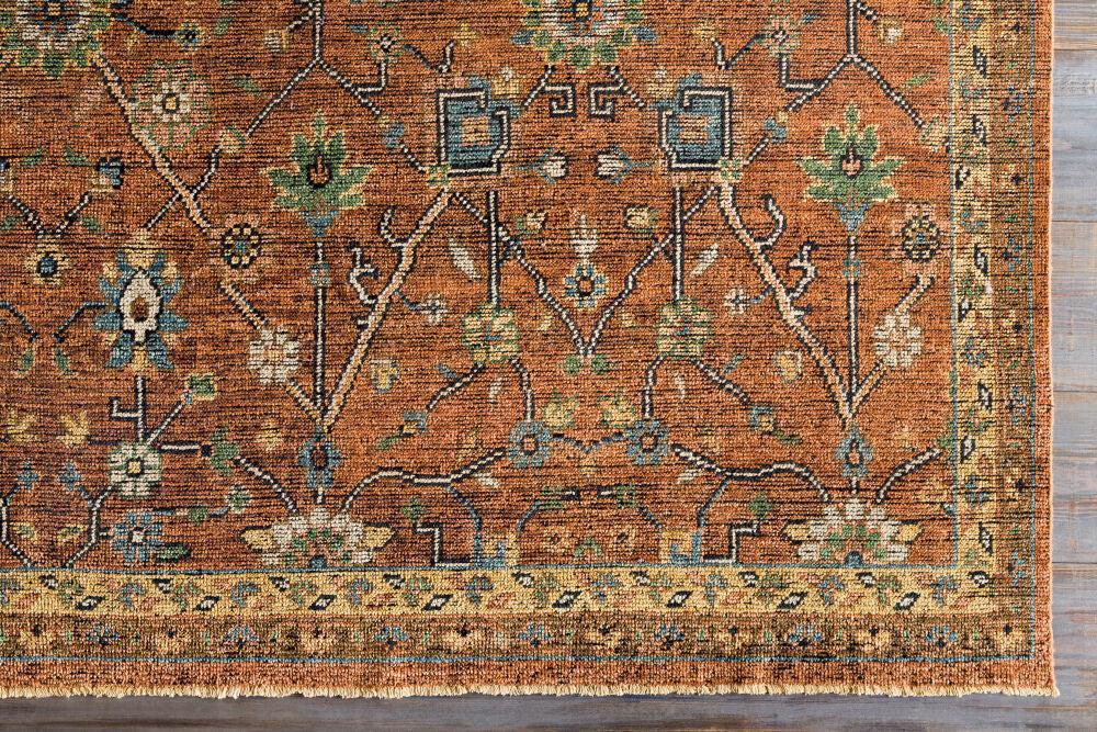 Reign hand-knotted wool rug in rust orange with traditional blue and green floral patterns.