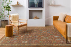 Reign hand-knotted wool rug with traditional rust and green patterns in a modern living room.