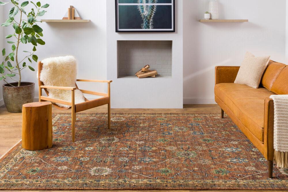 Reign hand-knotted wool rug with traditional rust and green patterns in a modern living room.