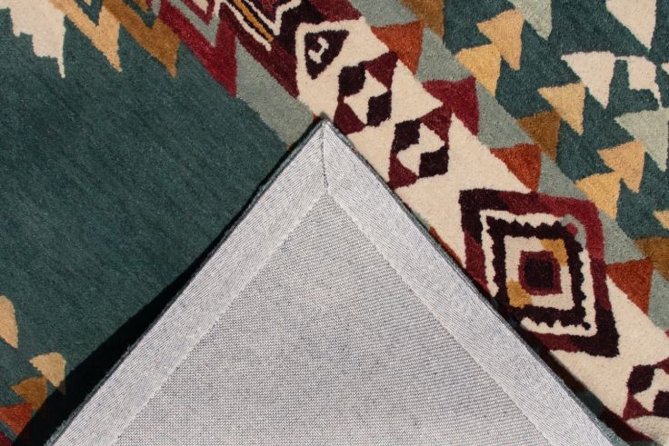 Teal Southwest hand-tufted wool rug showing geometric patterns and durable backing.