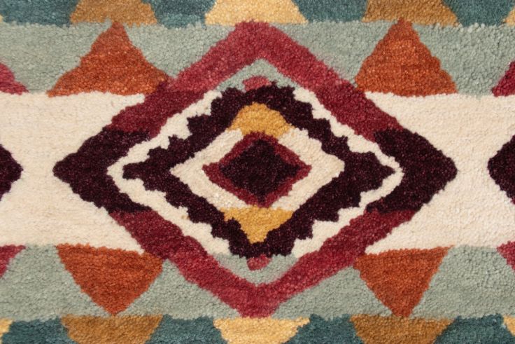 Southwest hand-tufted wool rug with teal, red, and cream geometric diamond patterns.