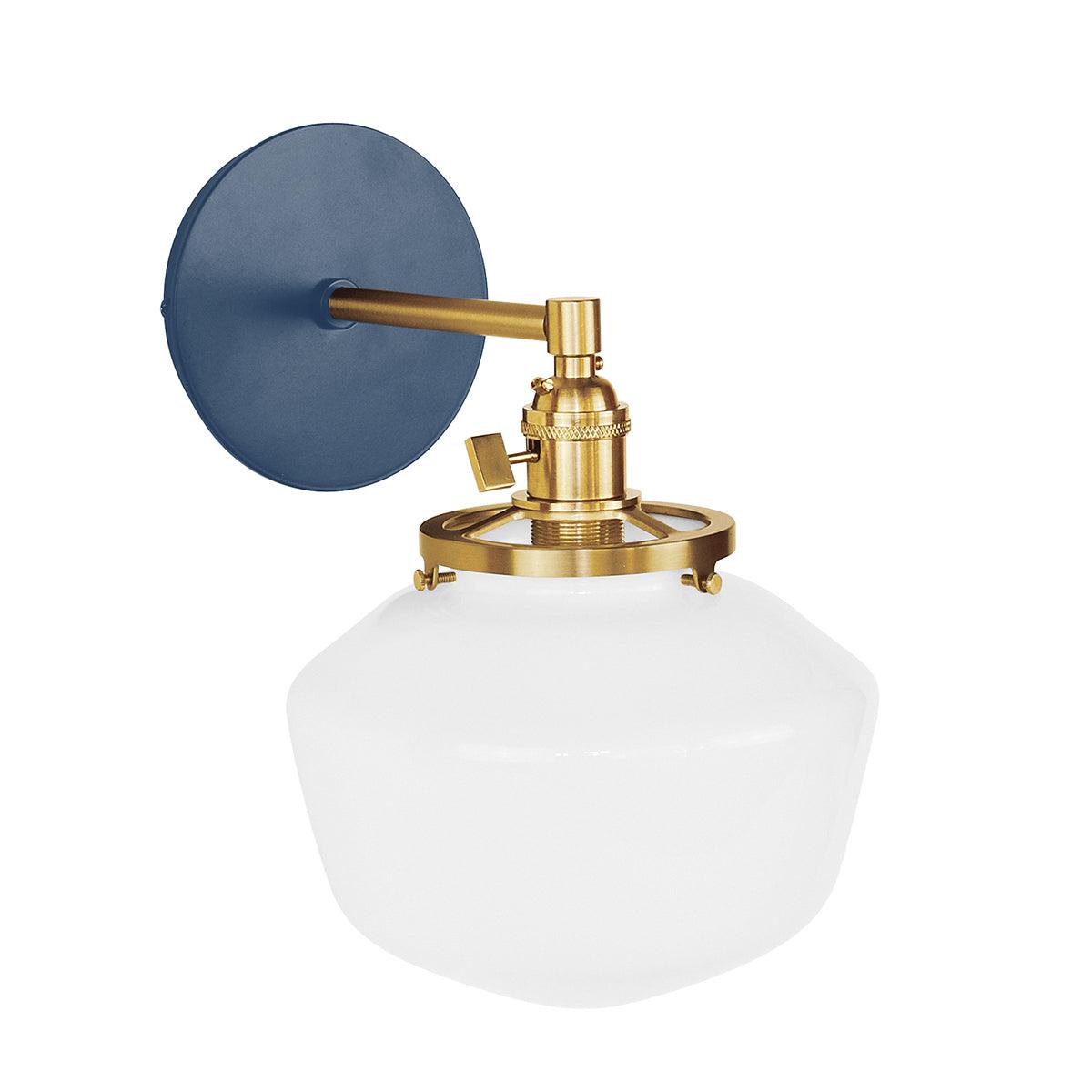 Uno Schoolhouse straight arm sconce with blue backplate, brass hardware, and white glass shade.